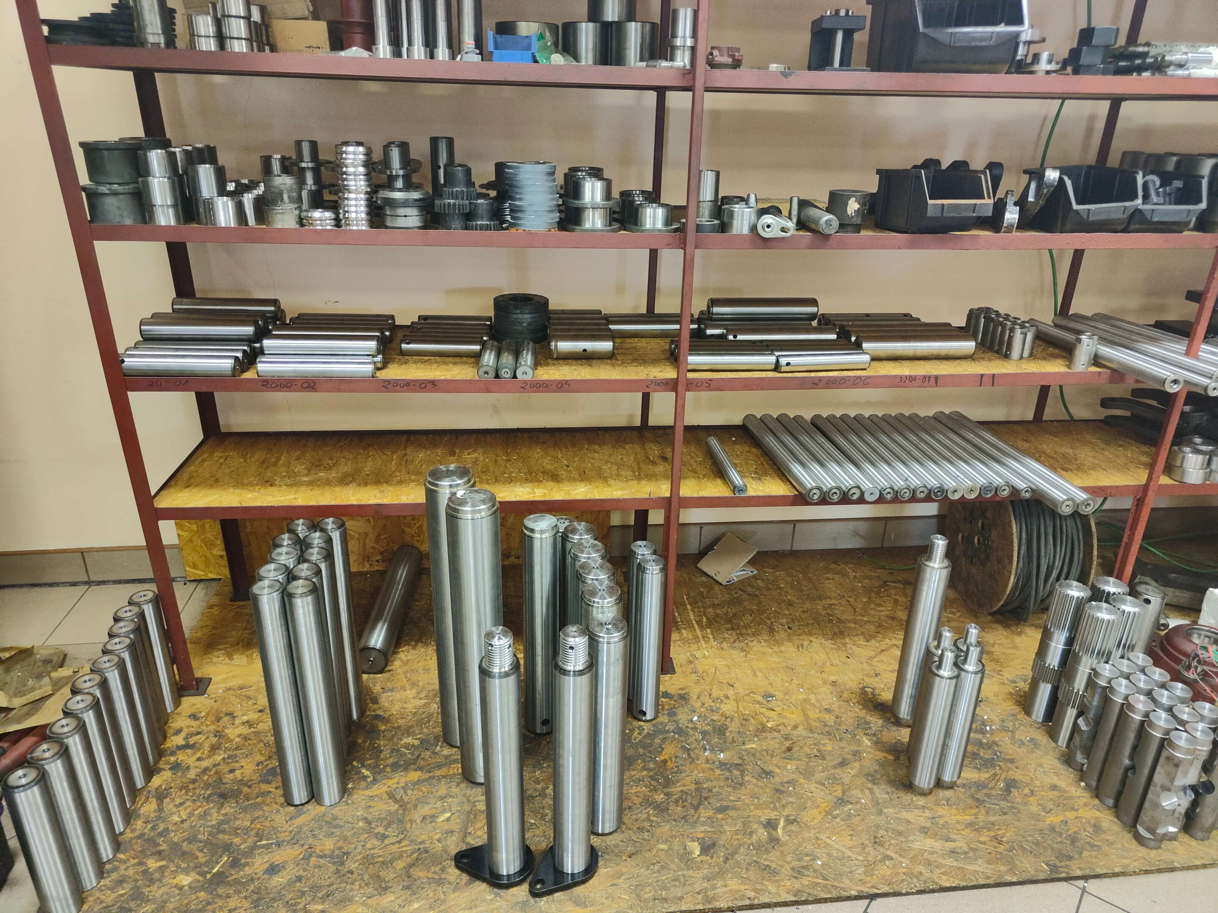 Regały magazynowe z gotowymi produktami: sworznie, tuleje i części maszyn oraz części zamienne do maszyn budowalnych